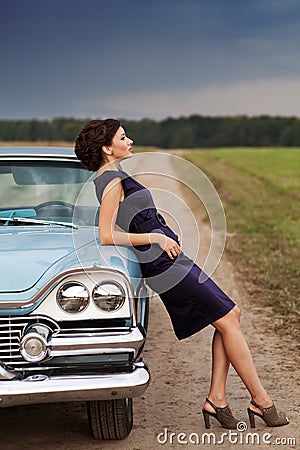 Beautiful lady standing near retro car