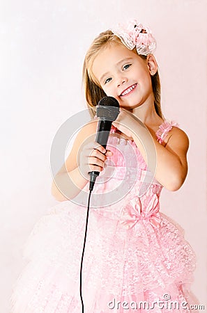 Beautiful little girl with microphone in princess dress