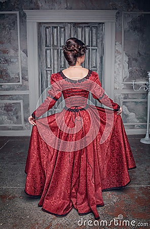 Beautiful medieval woman in red dress, back