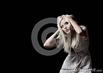 Beautiful scared young girl in the image of nurse on black background