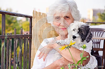 Beautiful senior woman hugging her dog