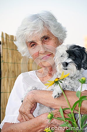 Beautiful senior woman hugging her dog