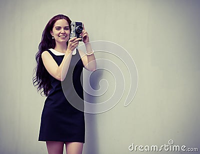 Beautiful sexy brunette with long hair with vintage camera in hand. Colorful hipster photo