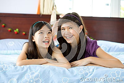 Beautiful sisters sharing a joke at home