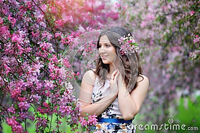 Beautiful smiling woman and pink flowers outside in spring