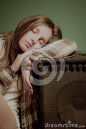 A beautiful teenage girl sleeping on a sound device