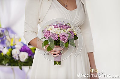Beautiful wedding bouquet of purple roses in the hands