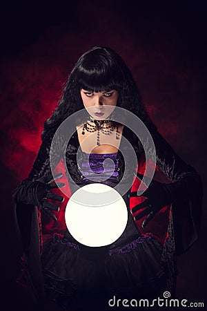 Beautiful witch or fortune teller with a crystal ball