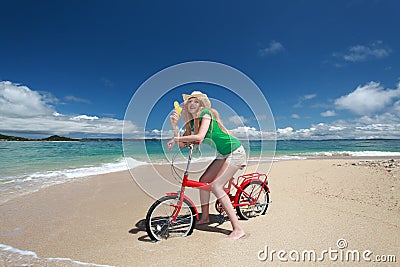 Beautiful woman on the bike on the beach