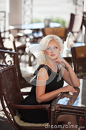 Beautiful woman in cafe restaurant, girl in bar, summer vacation. Pretty blond at breakfast. happy smiling woman