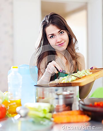 Beautiful woman cooking vegetarian salad
