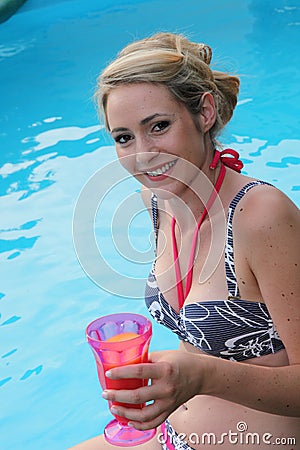 Beautiful woman enjoying a drink at the pool