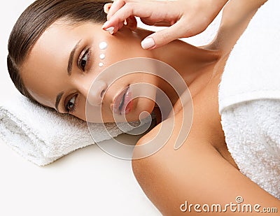 Beautiful Woman Getting Spa Treatment. Cosmetic Cream on a Cheek