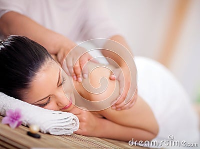 Beautiful woman having a wellness back massage at spa salon