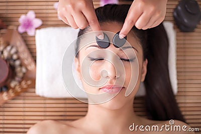 Beautiful woman having a wellness head massage with stones