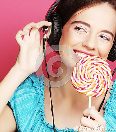 Beautiful woman with headphones and candy
