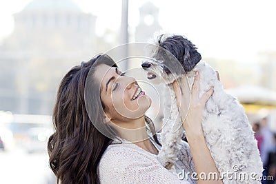 Beautiful woman hugging her little dog outdoor