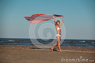 Beautiful woman jumping for joy desert beach