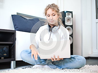 Beautiful woman with laptop sitting on the floor