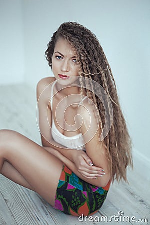 Beautiful woman with long hair in white room