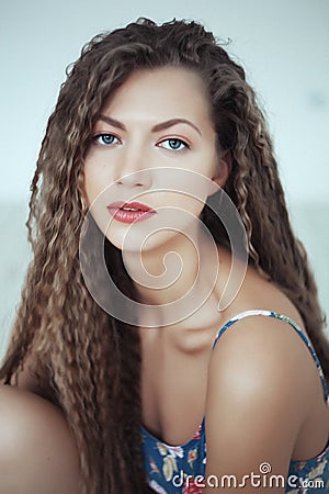 Beautiful woman with long hair in white room