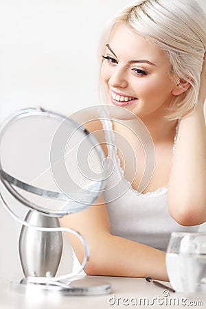 Beautiful Woman Looking at Her Face in the Miror Doing Daily Morning Makeup