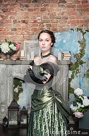 Beautiful woman in medieval dress near fireplace