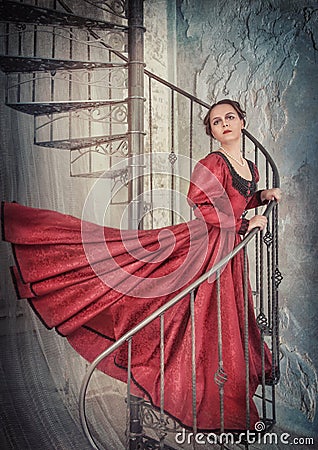 Beautiful woman in medieval dress on the stairway