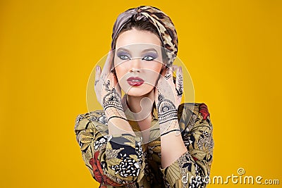 Beautiful woman in oriental style with mehendi in hijab