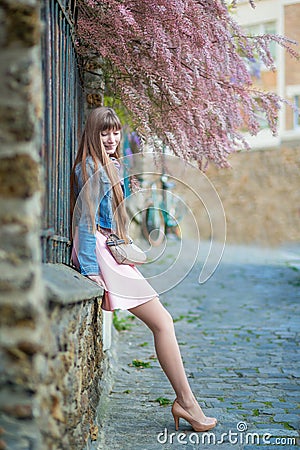 Beautiful woman in pink dress on a Parisian street