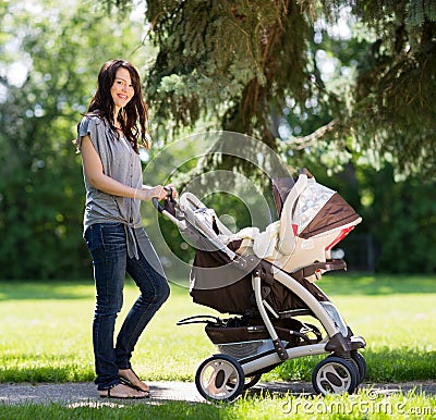 Beautiful Woman Pushing Baby Carriage In Park