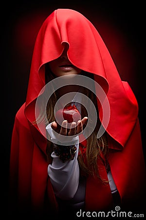 Beautiful woman with red cloak hoding apple