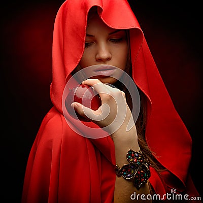 Beautiful woman with red cloak hoding apple