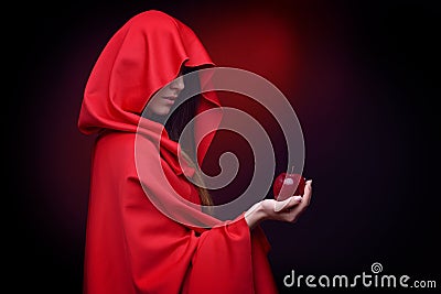 Beautiful woman with red cloak holding apple