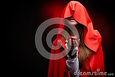 Beautiful woman with red cloak holding apple