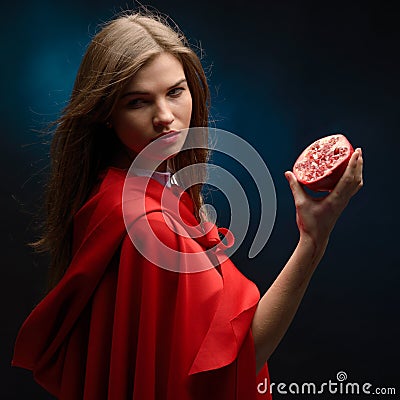 Beautiful woman with red cloak holding pomegranate