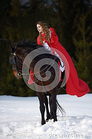 Beautiful woman with red cloak with horse outdoor
