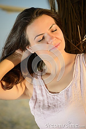 Beautiful woman relaxing, enjoying sunset on the beach