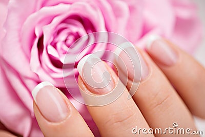 Beautiful woman s nails with french manicure and rose