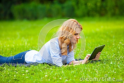 Beautiful woman sitting in park with laptop