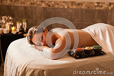 Beautiful woman in a spa relaxing on a massage tab