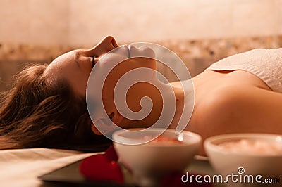 Beautiful woman in a spa relaxing on a massage tab