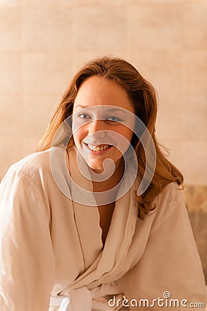 Beautiful woman in a spa wearing a white robe waiting for a mass