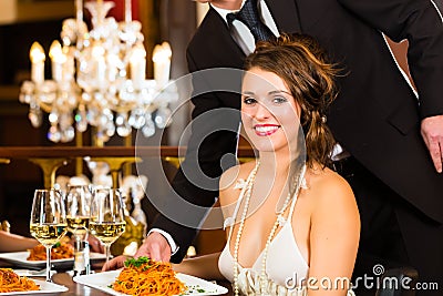 Beautiful woman and waiter in fine dining restaurant
