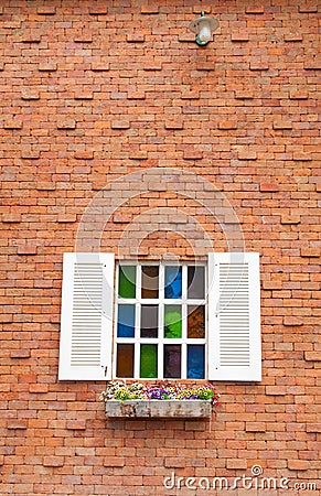 Beautiful wood window with multi color glass and brick wall