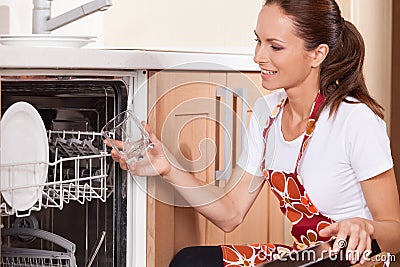 Beautiful young brunette washing dishes.