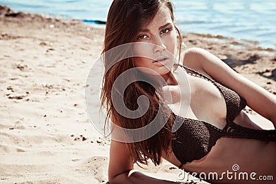 Beautiful young brunette woman on a sunny beach