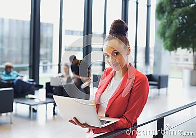Beautiful young businesswoman with laptop in modern office