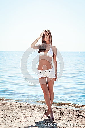 Beautiful young girl in a knitted swimsuit and shorts