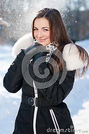 Beautiful young happy smiling woman getting warm on winter day